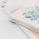 Album photo posé sur une table avec accessoires de scrapbooking à côté