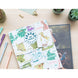 Album photo Around The World ouvert sur une table en bois avec des photos de voyage