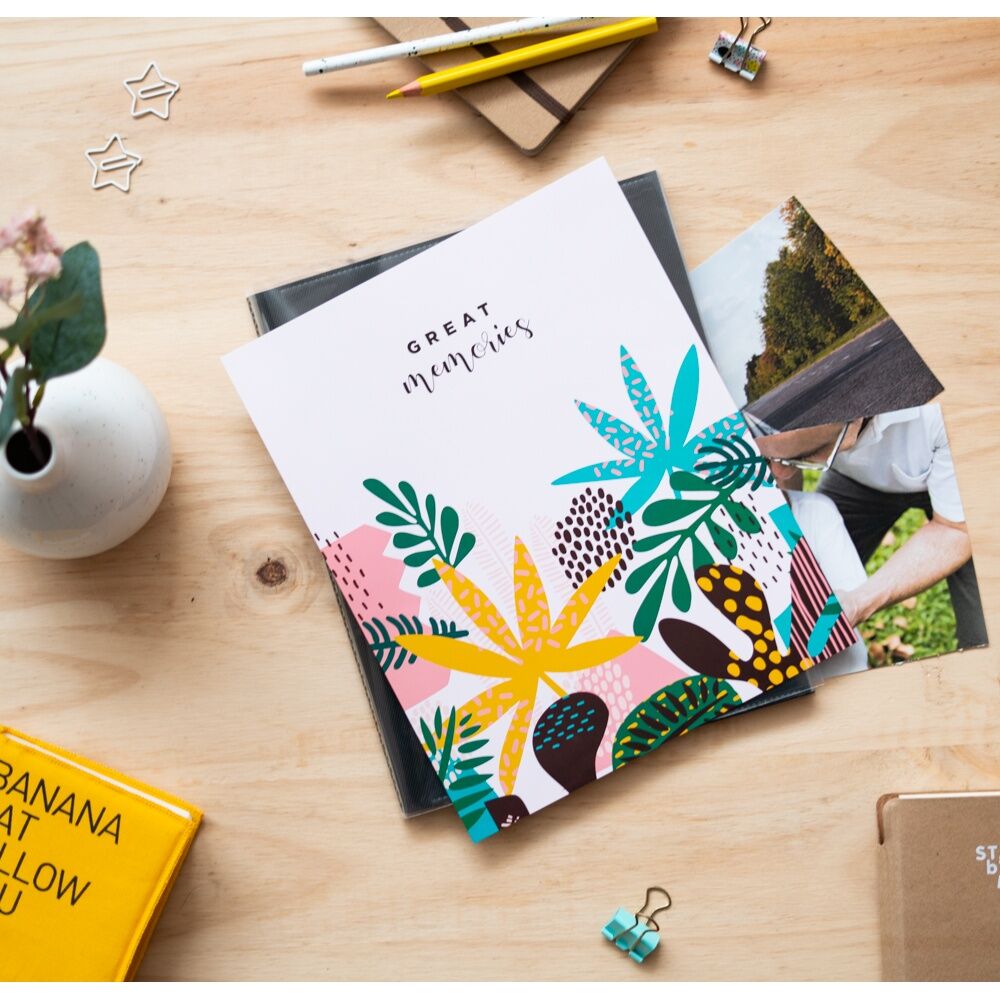 L'album photo Abstract Tropics posé sur une table en bois avec une ambiance tropicale