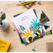 L'album photo Abstract Tropics posé sur une table en bois avec une ambiance tropicale