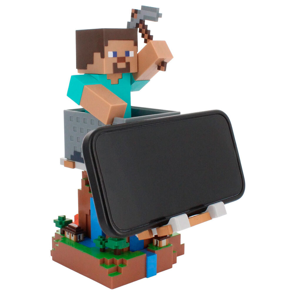 Support Cable Guy Minecraft Steve placé sur un bureau de gamer avec des accessoires de jeu.