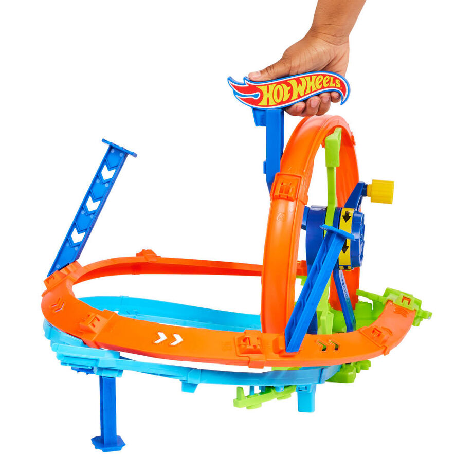 Enfant lançant la voiture Hot Wheels sur le circuit avec la boucle et la zone de crash pour des heures de jeu.