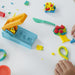 Enfant souriant en jouant avec le Play-Doh Fun Factory et la pâte colorée