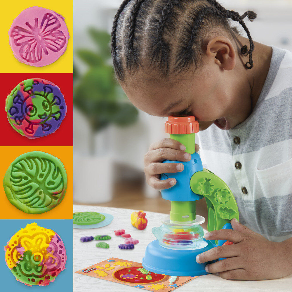 Enfant observant attentivement une création illuminée dans le microscope