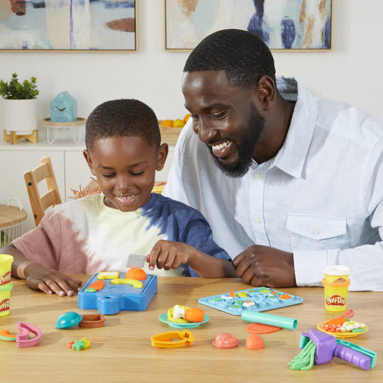 Enfant utilisant la planche à découper pour trancher la pâte à modeler