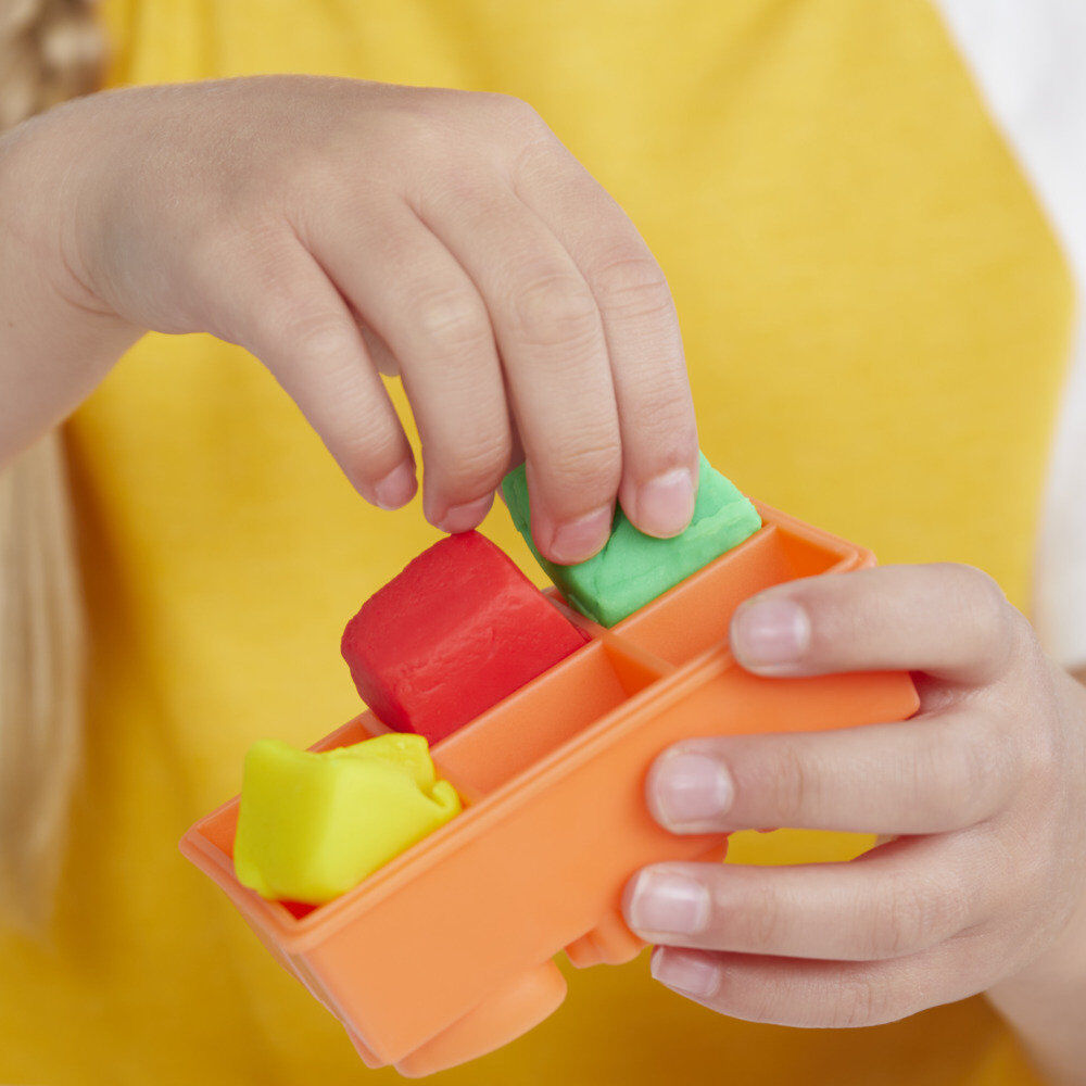 Enfant souriant tenant un smoothie Play-Doh créé avec le mixeur