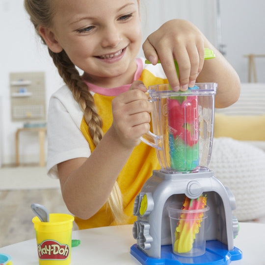Enfant concentré en train de créer un smoothie coloré avec le jeu Play-Doh