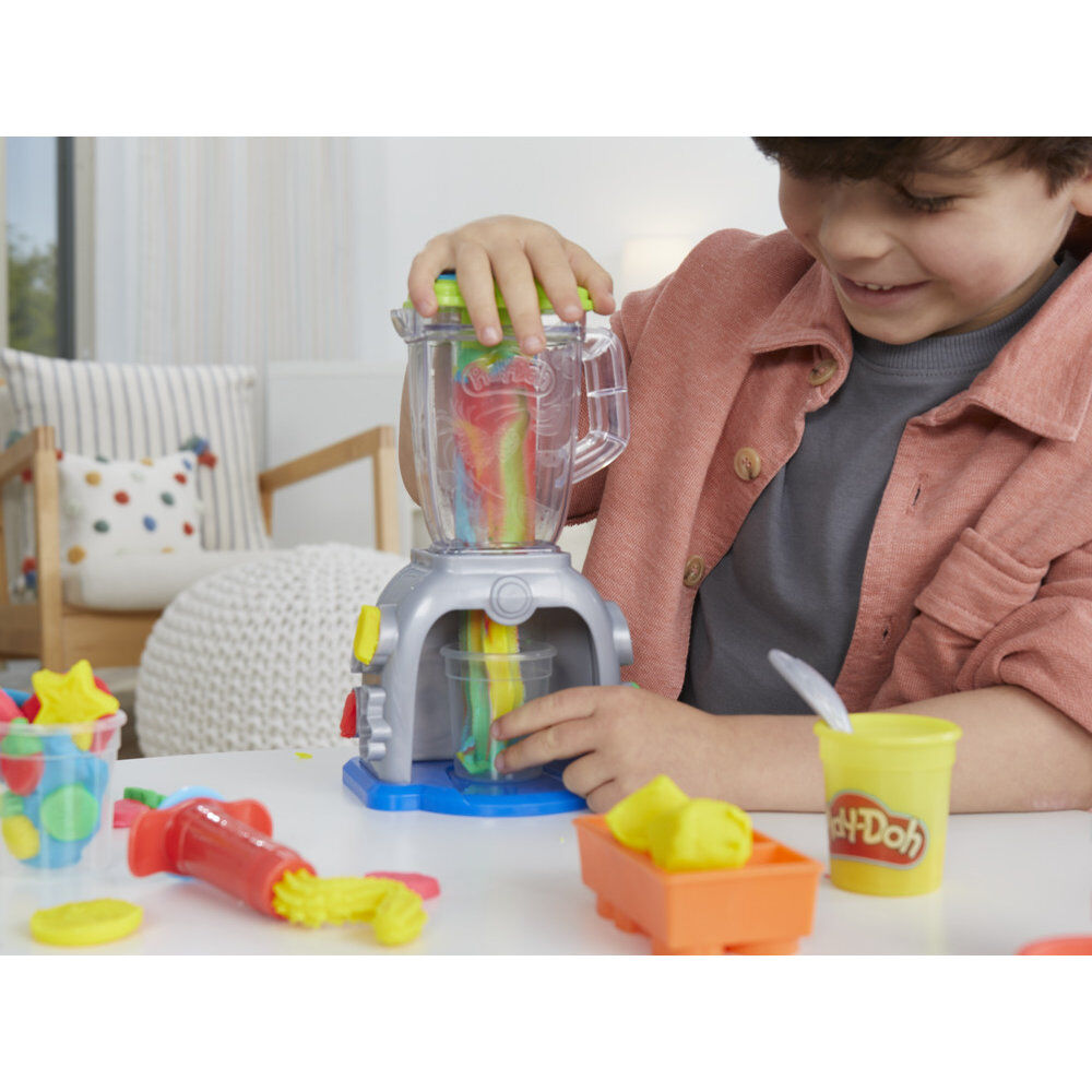 Enfant tenant plusieurs couleurs de pâte Play-Doh avant de les mélanger