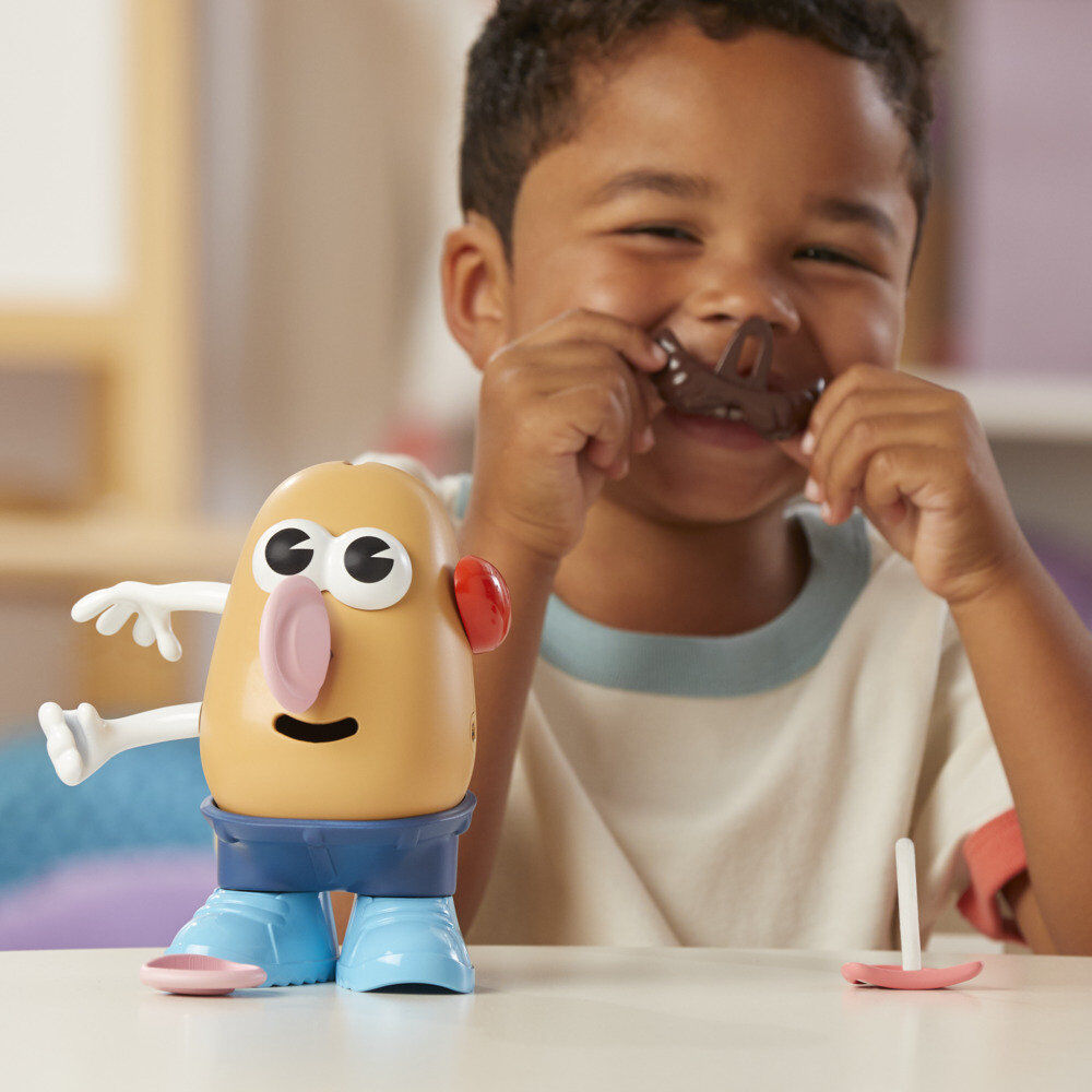 Enfant jouant avec Mr. Potato Head, assemblant les différentes parties sur le corps du jouet