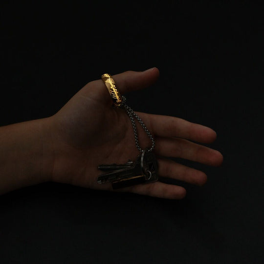 Photo rapprochée des gravures elfiques sur le porte-clés The One Ring, symbole de la saga Tolkien