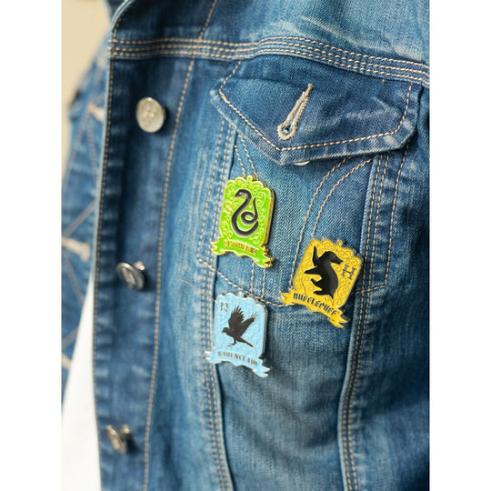 Ensemble des 4 pin's Harry Potter Poudlard posés sur un tissu noir pour mise en valeur