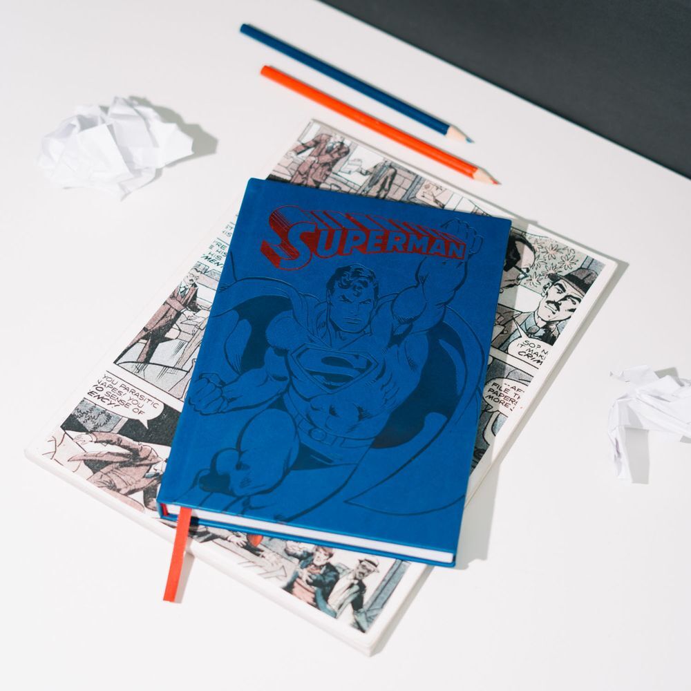 Cahier Superman A5 ouvert exposant la qualité des feuilles lignées et la reliure solide