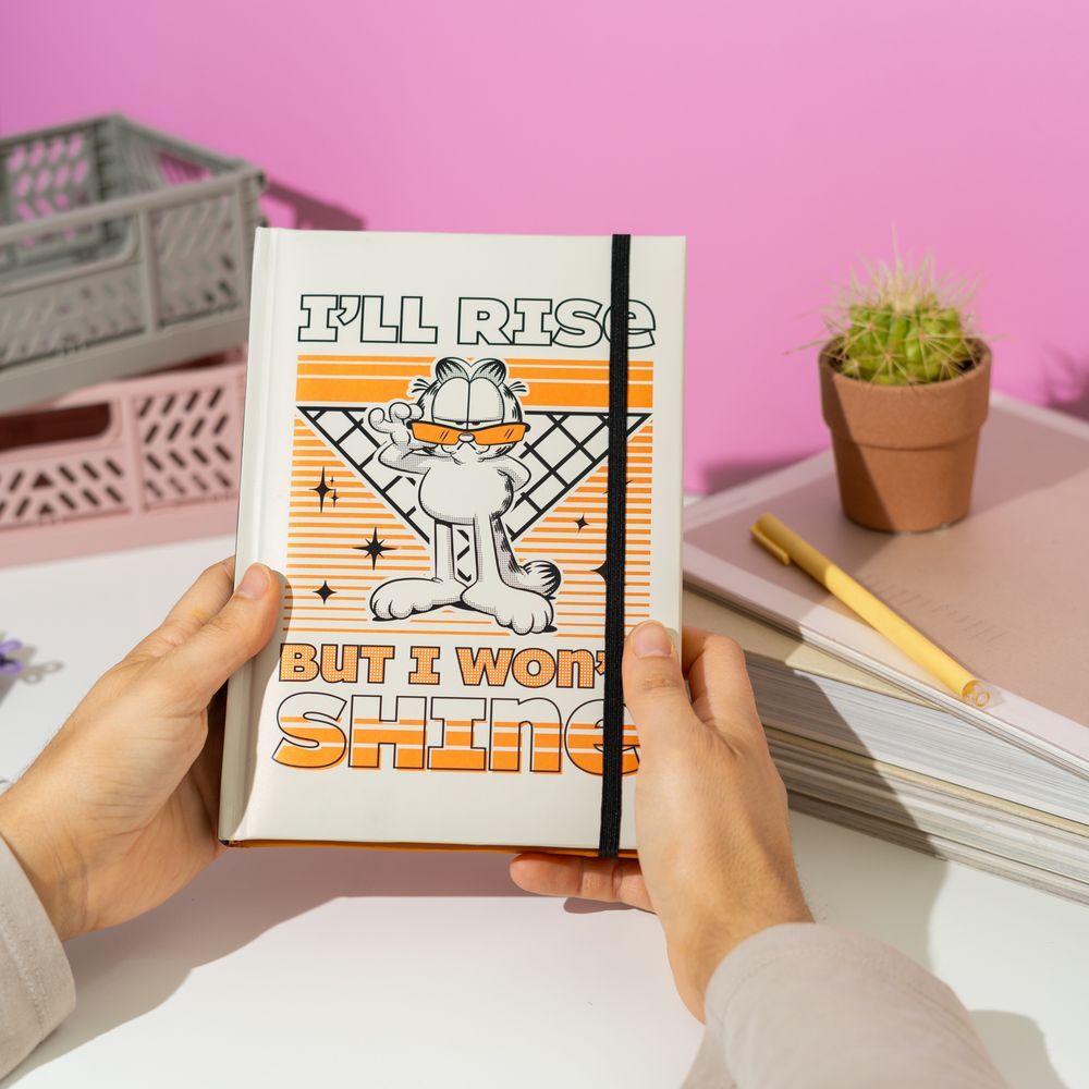 Présentation du carnet Garfield A5 posé sur un bureau avec accessoires d'écriture