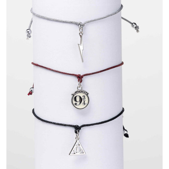 Bracelets d'amitié Harry Potter posés côte à côte montrant les détails des Reliques de la Mort et quai 9 3/4
