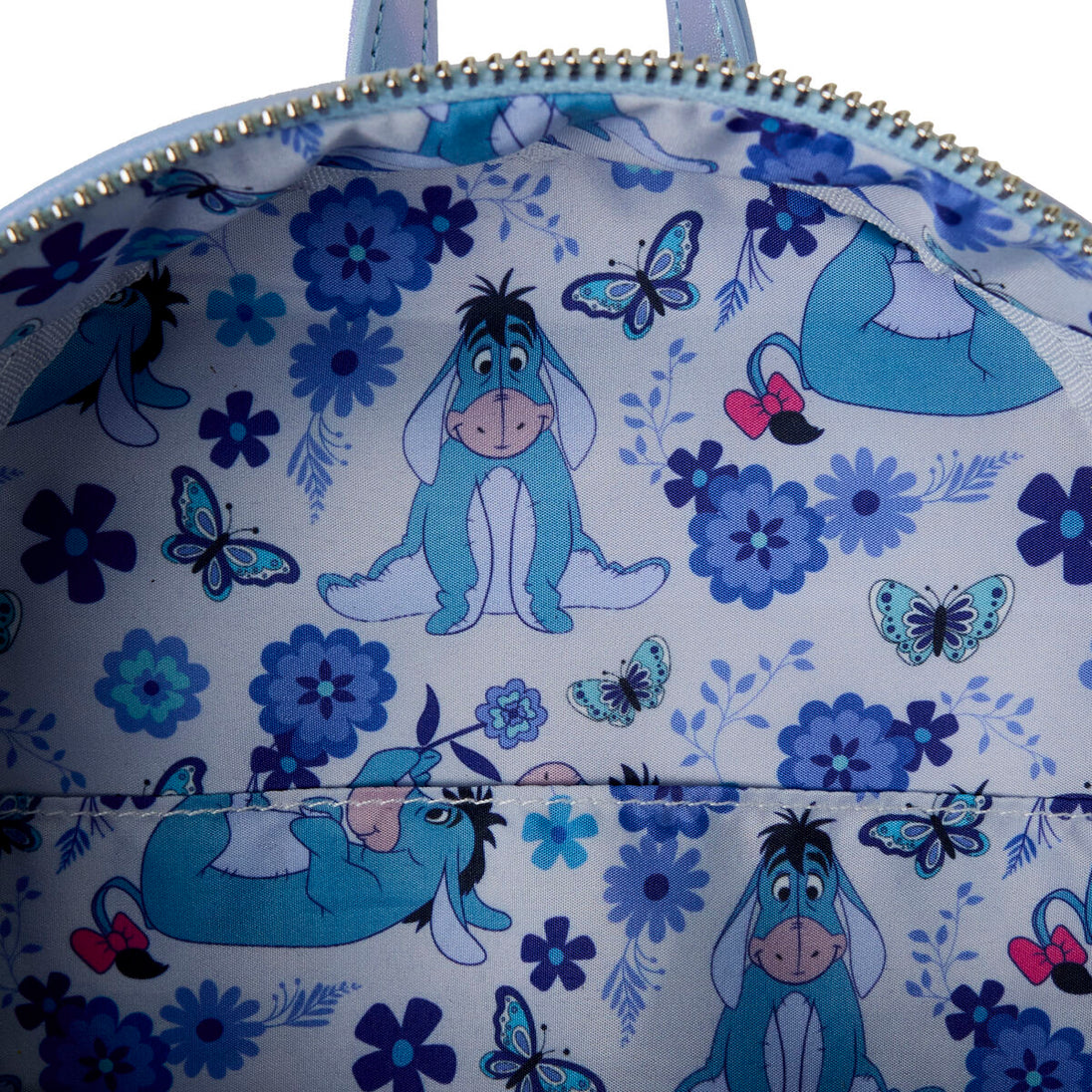 Détails rapprochés du sac à dos Loungefly Winnie l'Ourson, présentant les coutures et les éléments décoratifs uniques.