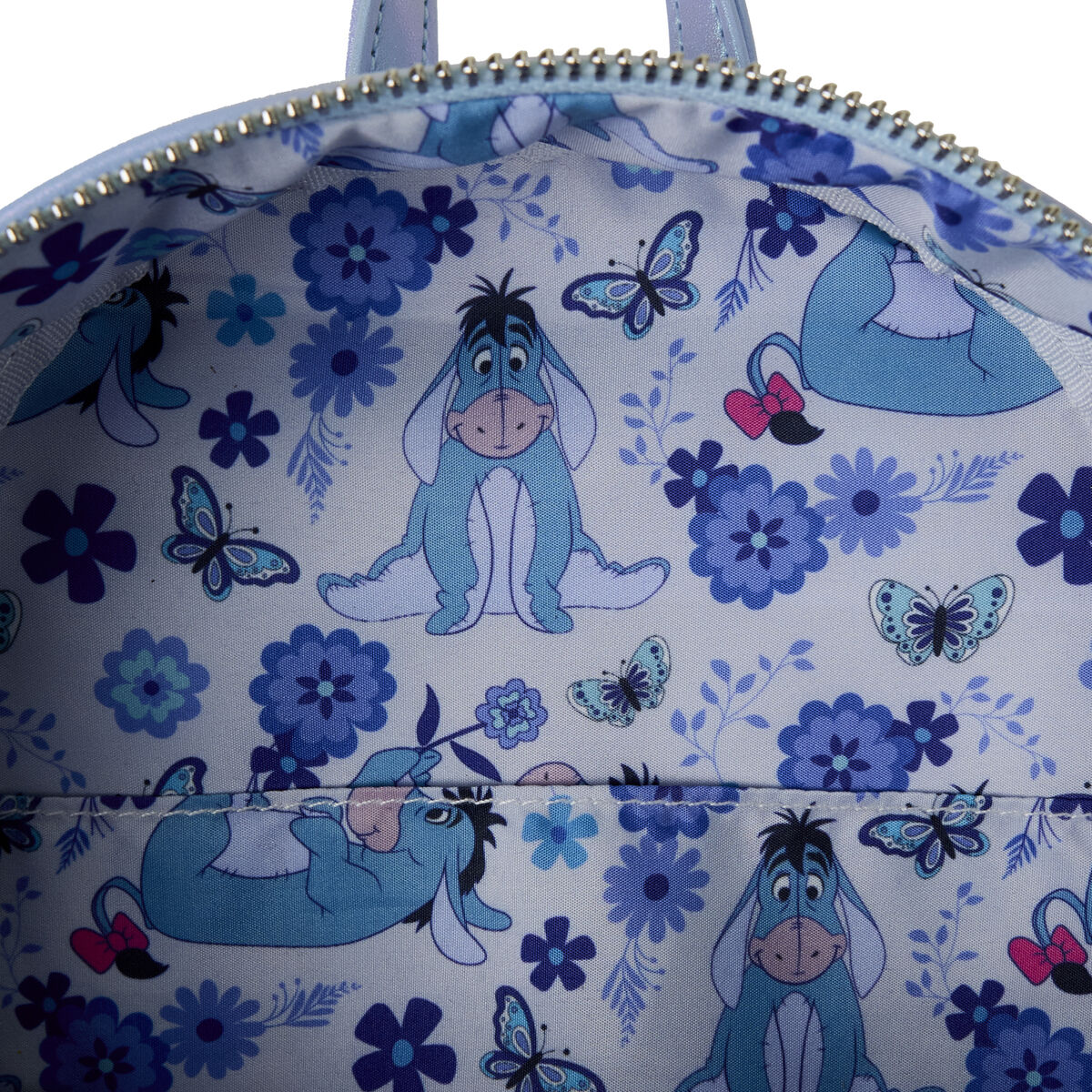 Détails rapprochés du sac à dos Loungefly Winnie l'Ourson, présentant les coutures et les éléments décoratifs uniques.