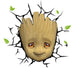 Lampe 3D LED Marvel Baby Groot Face allumée, fixée sur un mur blanc, créant un effet de fissure