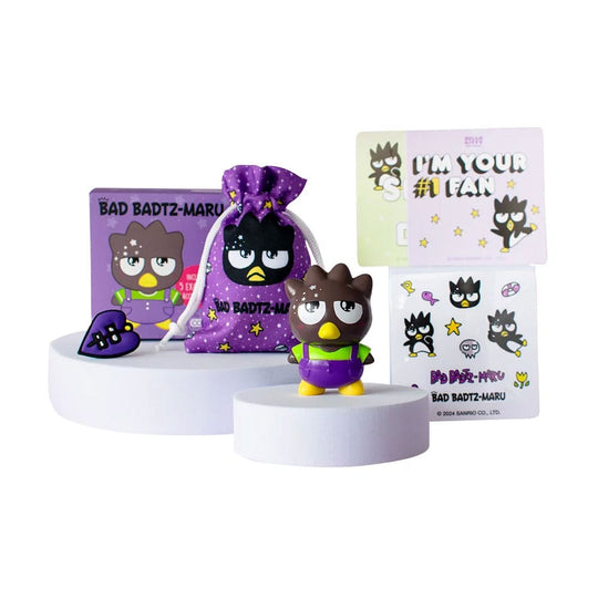 Mini figurine Badtzmaru Comansi 6 cm, style Kawaii, avec ses 5 accessoires exclusifs (cartes postales, autocollants, breloque, sac en coton) présentés à côté.