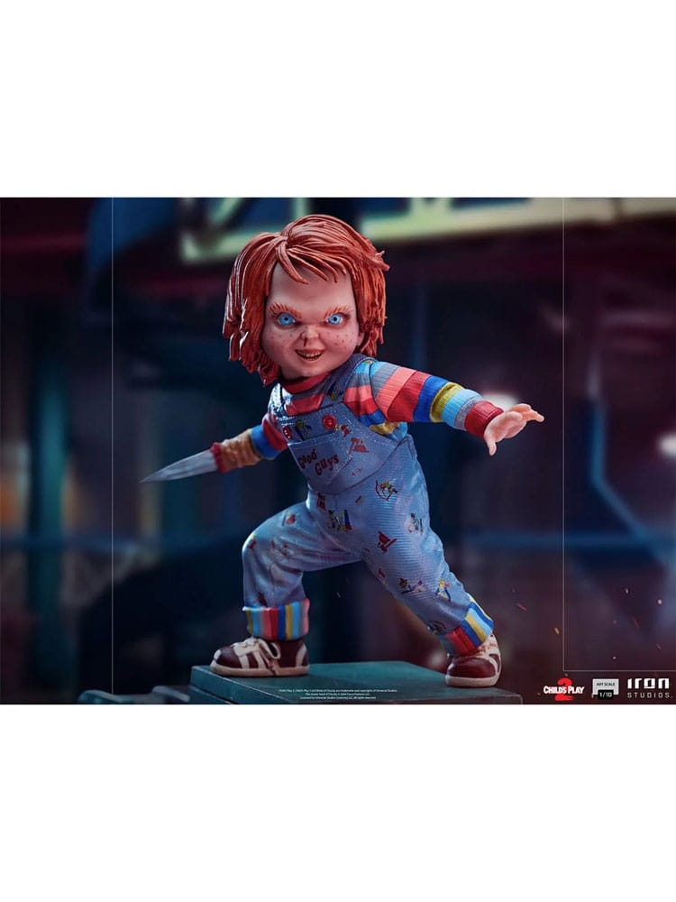 Gros plan sur le visage menaçant de la statuette Chucky, yeux et cicatrices visibles