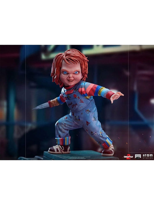 Gros plan sur le visage menaçant de la statuette Chucky, yeux et cicatrices visibles