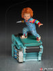 Vue rapprochée de la base de la statuette Chucky, avec des éléments de décor