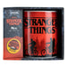 Mug Stranger Things et autocollant XL posés sur une surface, montrant la taille
