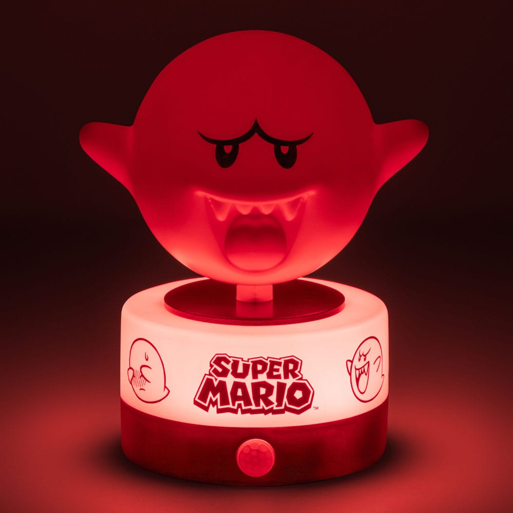 Lampe Boo Super Mario à côté d'une console de jeu, créant une ambiance immersive.