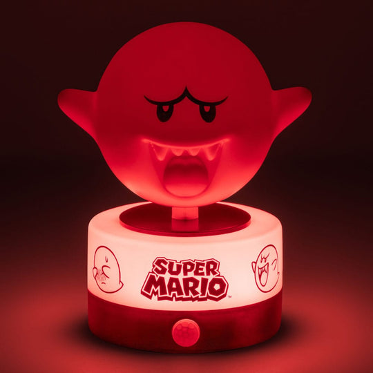 Lampe Boo Super Mario à côté d'une console de jeu, créant une ambiance immersive.